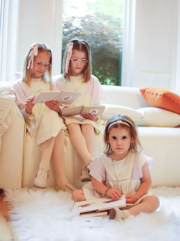 Three sisters reading together in a bright room, studio photography by Photoholic, Monsey NY
